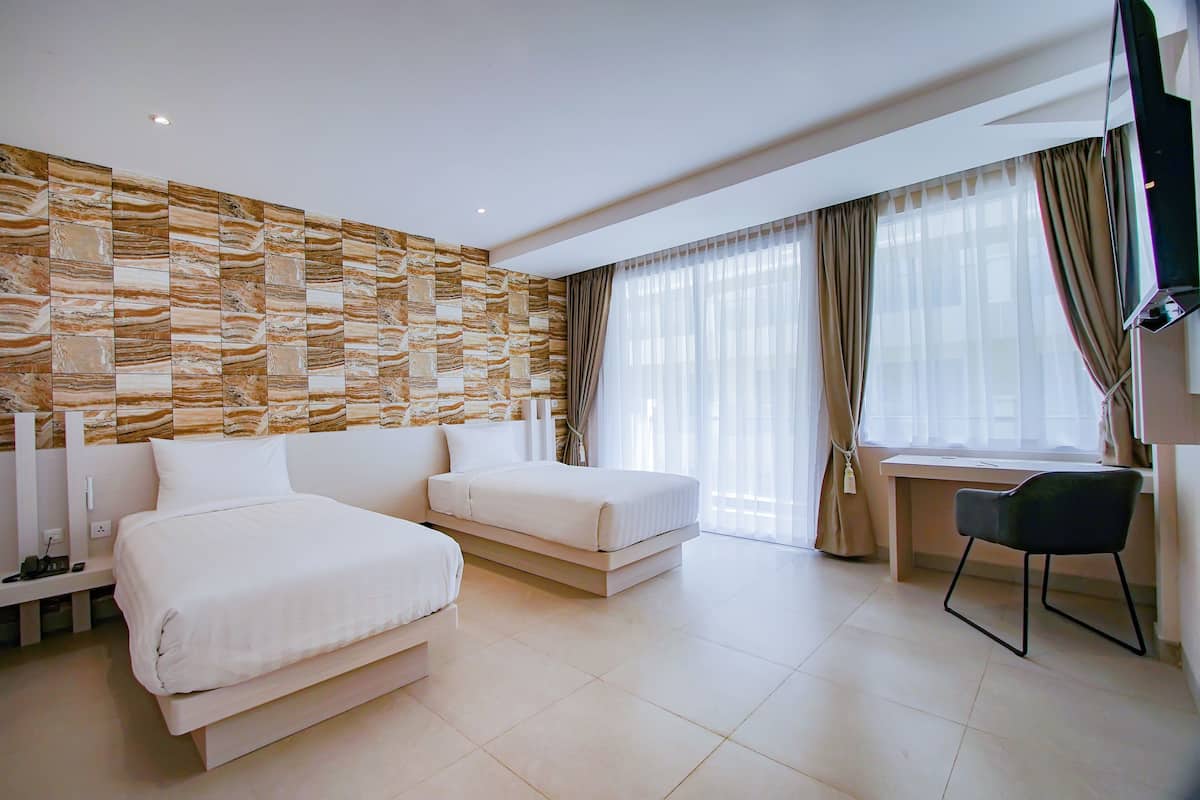 Una habitación de hotel moderna con una cama grande, un escritorio y un televisor.