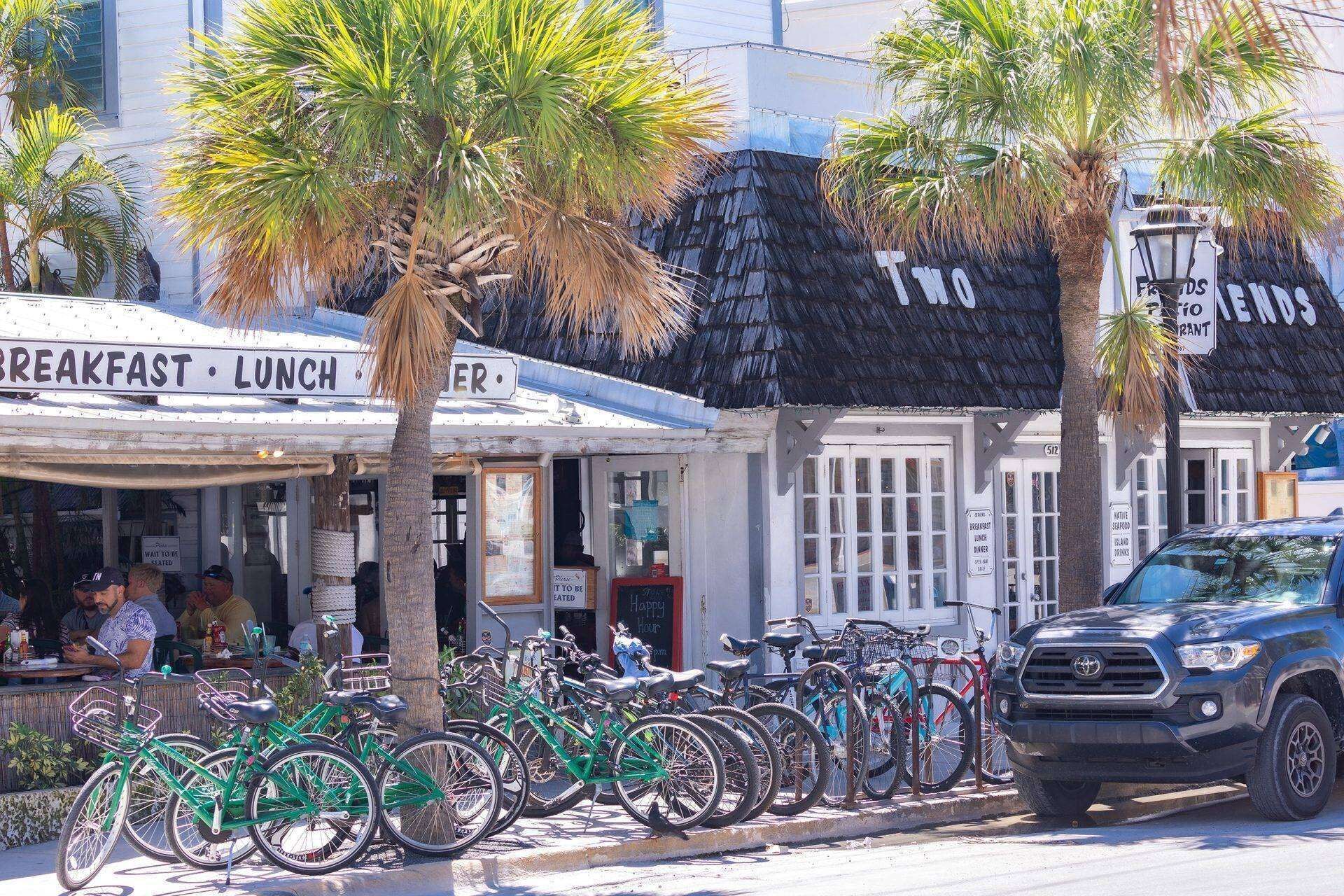 Un restaurant situé en bord de mer, avec un panneau indiquant les heures des repas : petit-déjeuner, déjeuner et dîner.