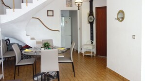 Ein Essbereich mit einem runden Tisch, Stühlen und einer Treppe.