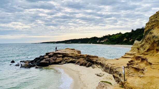 A coastal beach with rocky formations, clear water, and a distant view of the sea. - Bay Rd | Kids & Pet Friendly | Free Parking (Cheltenham)