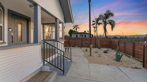 Il s’agit d’une propriété résidentielle dotée d’un porche couvert, d’une terrasse en béton et offrant une vue sur des palmiers et un coucher de soleil.