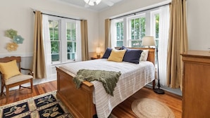 A bedroom with a bed, a chair, a desk, and a window. - Downtown Executive Retreat (Hickory)