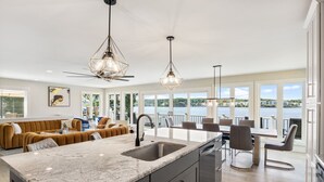 Een moderne keuken met een groot eiland, een eetgedeelte met uitzicht en een gezellige zithoek.