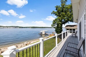 Une terrasse offrant une vue sur un lac, un quai et une rive éloignée.