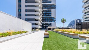 A modern urban building with multiple balconies and a well-maintained courtyard with grass and plants. - Alexia II 123 - Grupo Turis - Calpe, Costa Blanca (Calpe)