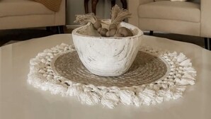 Una sala de estar con dos sofás, una mesa de centro con un cuenco decorativo y una cortina.