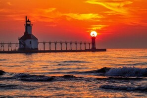 Un faro y muelle al atardecer.