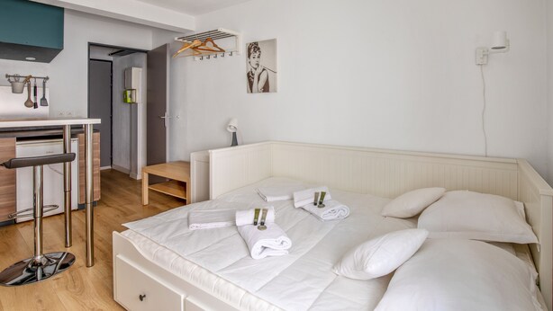 Quarto de hotel moderno com uma cama grande, uma escrivaninha e um candeeiro suspenso.