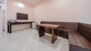 Um interior moderno com um banco de madeira e uma televisão de tela plana fixada na parede.