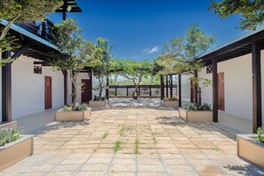 A courtyard with a tiled floor, surrounded by buildings with wooden beams and white walls. - 86 Highlands (Liuqiu)