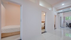 Quarto de hotel moderno com uma cama grande, uma mesa e uma cadeira. Há uma janela com vista para o verde lá fora.