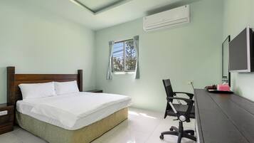 Un dormitorio con una cama, un escritorio y una silla.