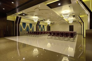 A conference room with a long row of chairs, a polished floor, and a modern ceiling design with recessed lighting. - Hotel Jhankar Palace (Dhule)
