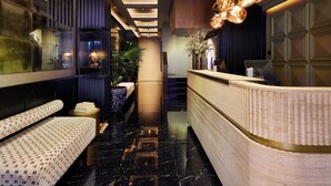 A modern hotel lobby with a reception desk, seating area, and a staircase. - MIM Andorra Member of Meliá Collection (Escaldes-Engordany)