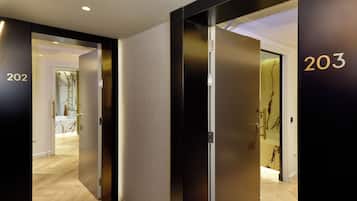 Un pasillo moderno de hotel con puertas numeradas 202 y 203, que dan acceso a las habitaciones.