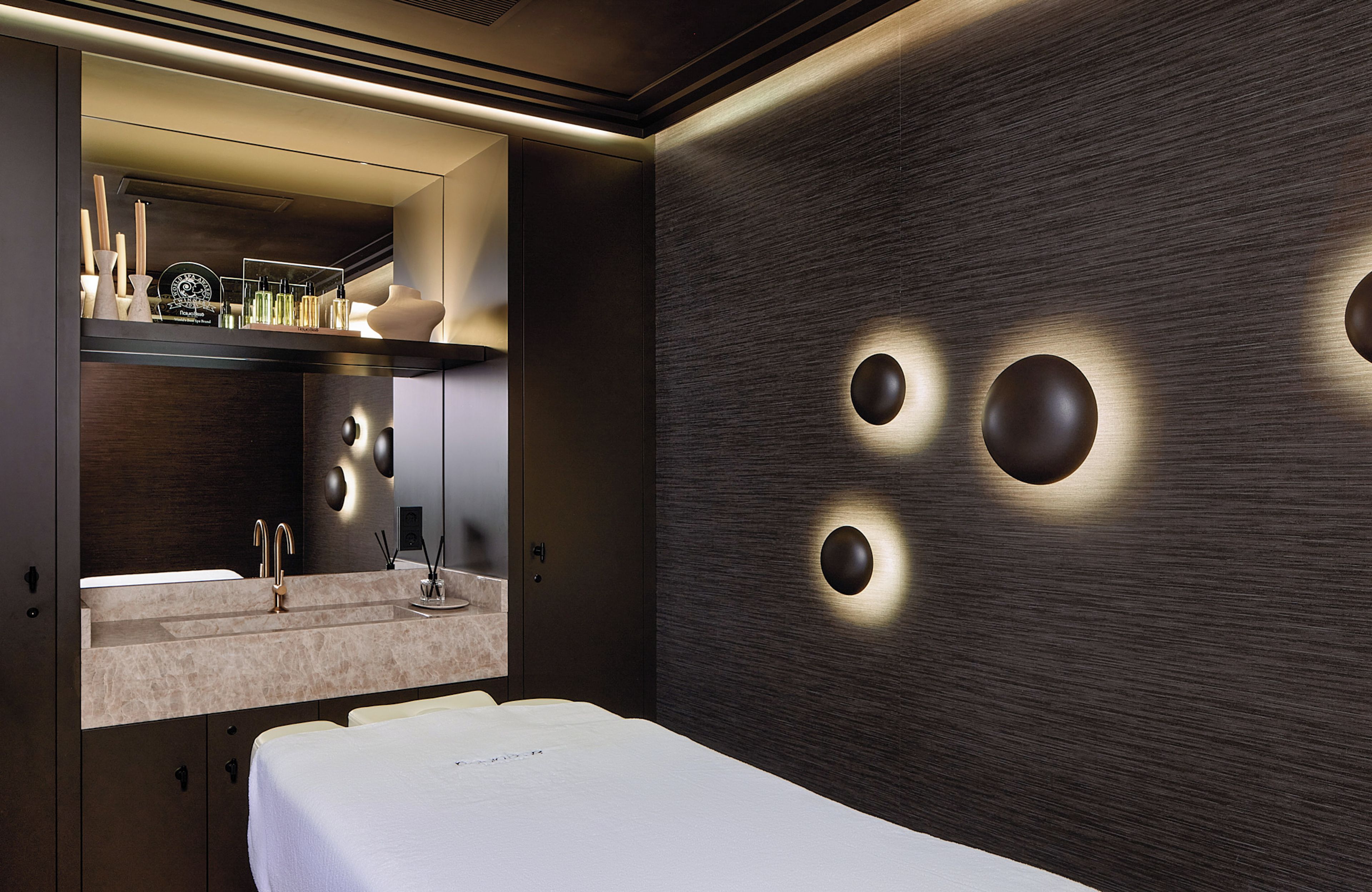 A modern bathroom with a vanity, mirror, and three wall-mounted lights.