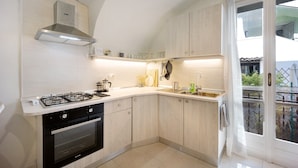 A kitchen with a gas stove, oven, and stainless steel range hood.