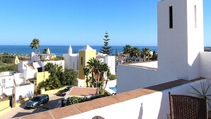 Eine Küstenstadt mit weißen Häusern, blauem Himmel und Blick aufs Meer.