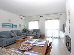A living room with a sofa, a coffee table, and a TV.