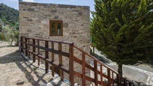 A stone building with a wooden staircase and a small window.