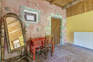 A room with a wooden-framed mirror, a red bench, a wooden door, and a radiator.