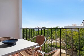 A balcony with wicker chairs and a table, overlooking a green landscape and buildings. - Apartment 'Casa Miriam' with Balcony and Wi-Fi (Conil de la Frontera)