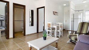 A spacious living area with a dining table, chairs, a sofa, and a refrigerator. - Apartment 'Casa Mar' with Balcony, Wi-Fi and Air Conditioning (Conil de la Frontera)