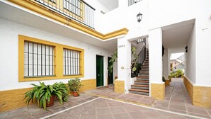 A courtyard with a staircase leading to an upper floor, potted plants, and a door marked 'ESC2'. - Vacation Apartment "Dúplex Chanca" with Private Terrace (El Puerto de Sta María)