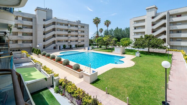 A swimming pool surrounded by greenery, with multi-story buildings in the background. - Holiday Apartment "Cambrils Park" with Sea View, Balcony & Shared Pool (Cambrils)