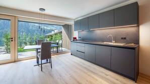A modern kitchen with a large window, a dining area, and a view of a mountainous landscape. - Studio Apartment 'Garden Lodge Exclusive Two' with Mountain View, Private Terrace and Wi-Fi (Sankt Martin in Passeier)