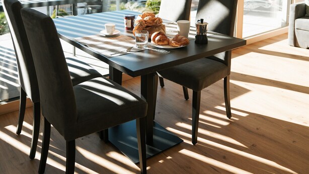 A dining area with a table, chairs, and a view of the mountains. - Apartment "Lodge Terrace Exclusive Large" with Mountain View & Wi-Fi (Sankt Martin in Passeier)