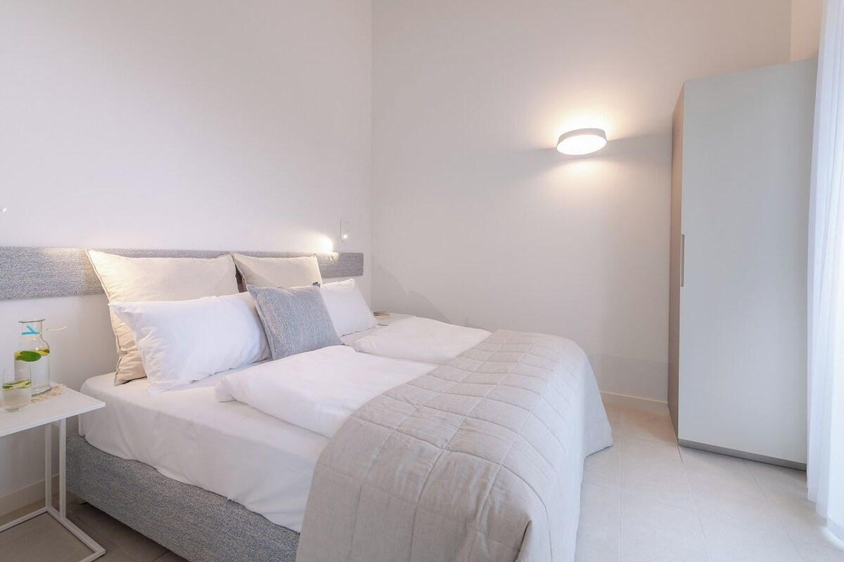 Une chambre à coucher moderne avec un lit, une table de chevet et une armoire.