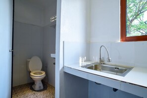 Un baño con inodoro, lavamanos y ventana.