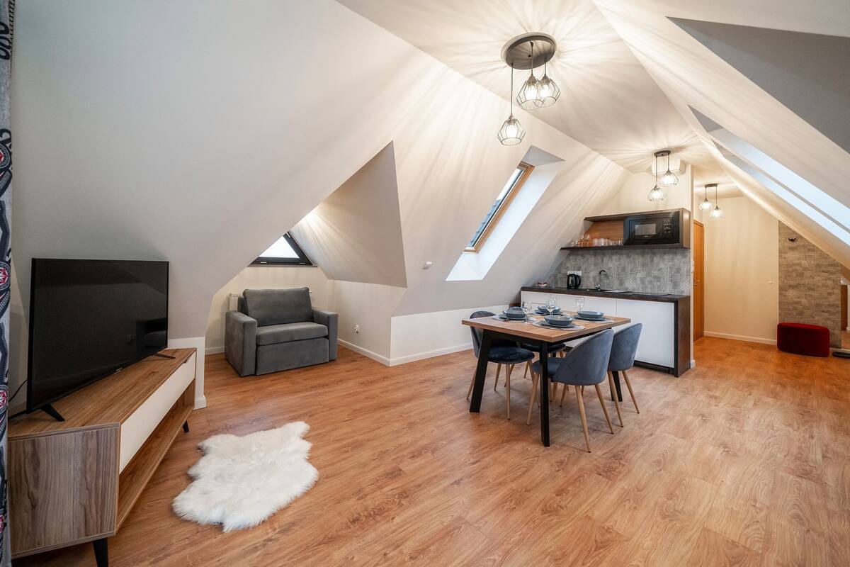 Um apartamento loft moderno com área de refeições, cozinha e sala de estar.