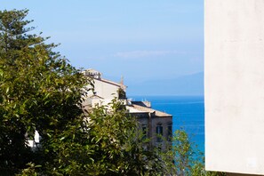 Un edificio con vista al mar, rodeado de vegetación.