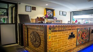 A bar area with a brick design, a mounted television, and decorative elements. - MeroStay 139 Hotel Mandala (Kathmandu)