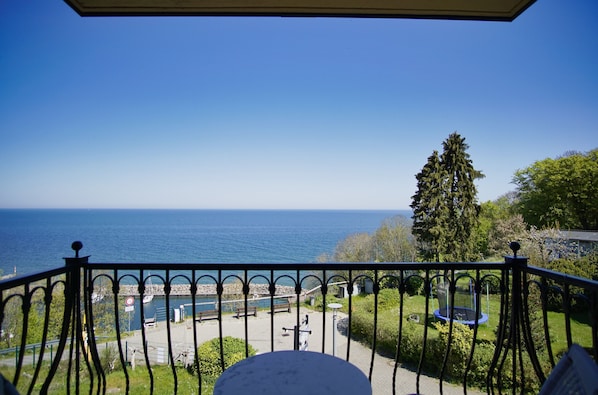 A balcony with a view of the sea, a garden with a trampoline, and a clear blue sky. - Die Ferienwohnung Nr. 06 im Haus am Meer (Lohme)