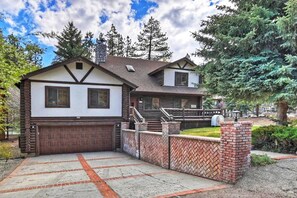 Ein zweistöckiges Haus mit Garage, überdachter Veranda und einem Steinkamin.