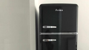 A black Amica refrigerator with two doors, a teal trash bin, and patterned floor tiles. - Apartamento en el Casco Antiguo de Pamplona - Ayla Camino de Santiago (Pamplona/Iruña)