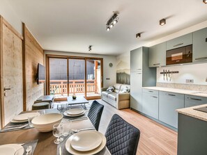 Enjoy meals and relaxation in this spacious kitchen and dining area, featuring an oven, sink, and comfortable seating for four.