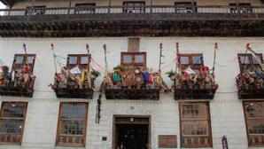 Un edificio con varios balcones decorados con banderas y adornos coloridos.
