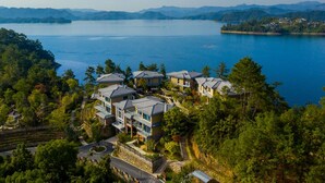 A residential area with houses overlooking a large body of water and mountains in the background. - Bright QiandaoLake Resort (Hangzhou)