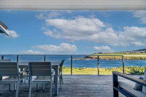 Enjoy ocean views from this outdoor seating area with a deck, tables, and chairs.