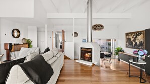 Un salon moderne avec une cheminée, un plancher en bois et un canapé.