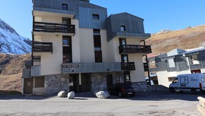 Un edificio a più piani con balconi, facciata in pietra e un cartello con su scritto "LE PLEIN SOLEIL".