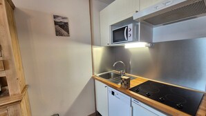 Una cucina compatta con microonde, lavello e lavastoviglie.