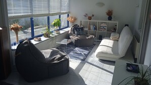 Un salon moderne avec un canapé, un fauteuil poire, une table basse et une bibliothèque.