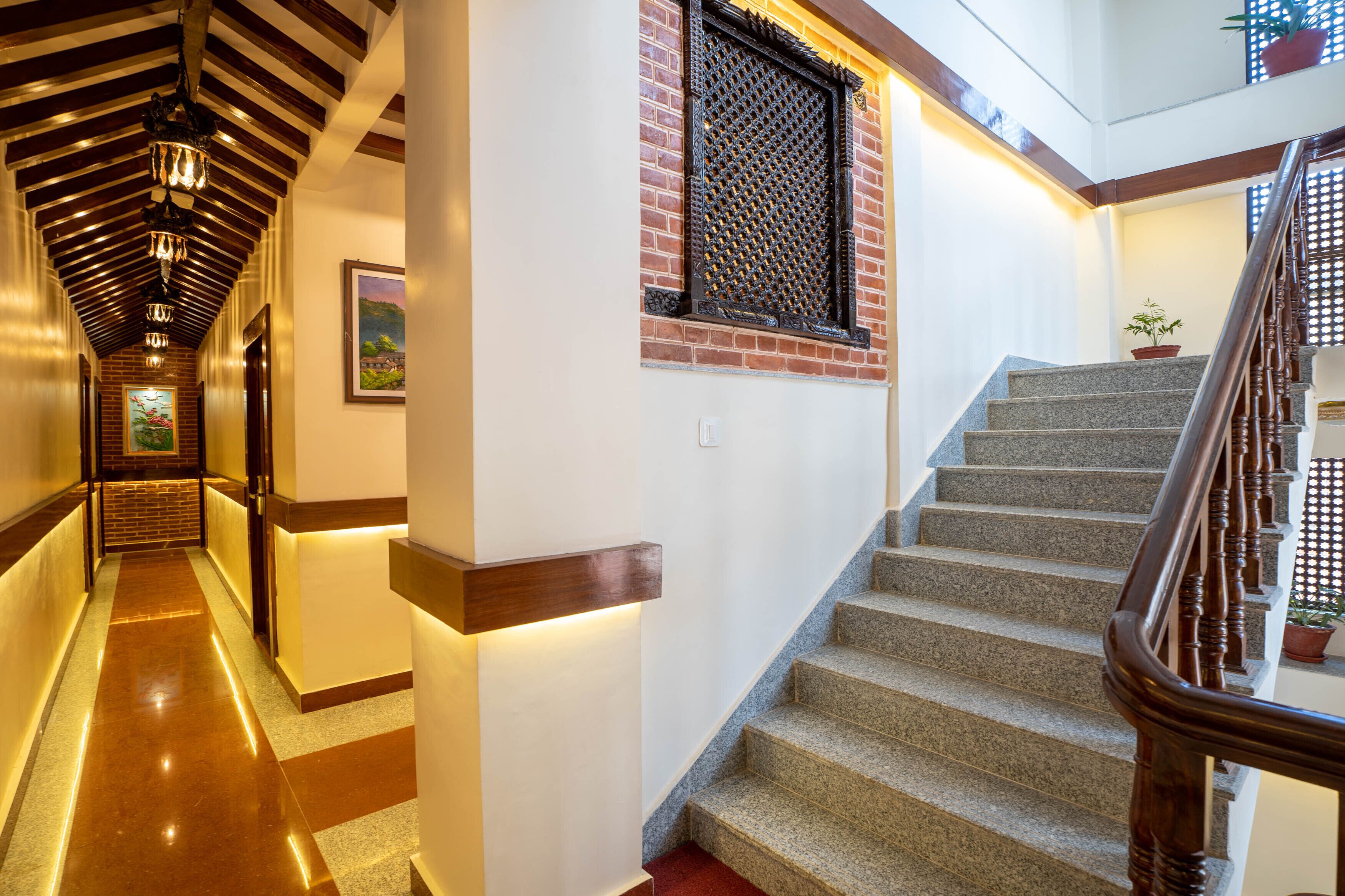 A staircase with a wooden handrail and a potted plant on the landing.