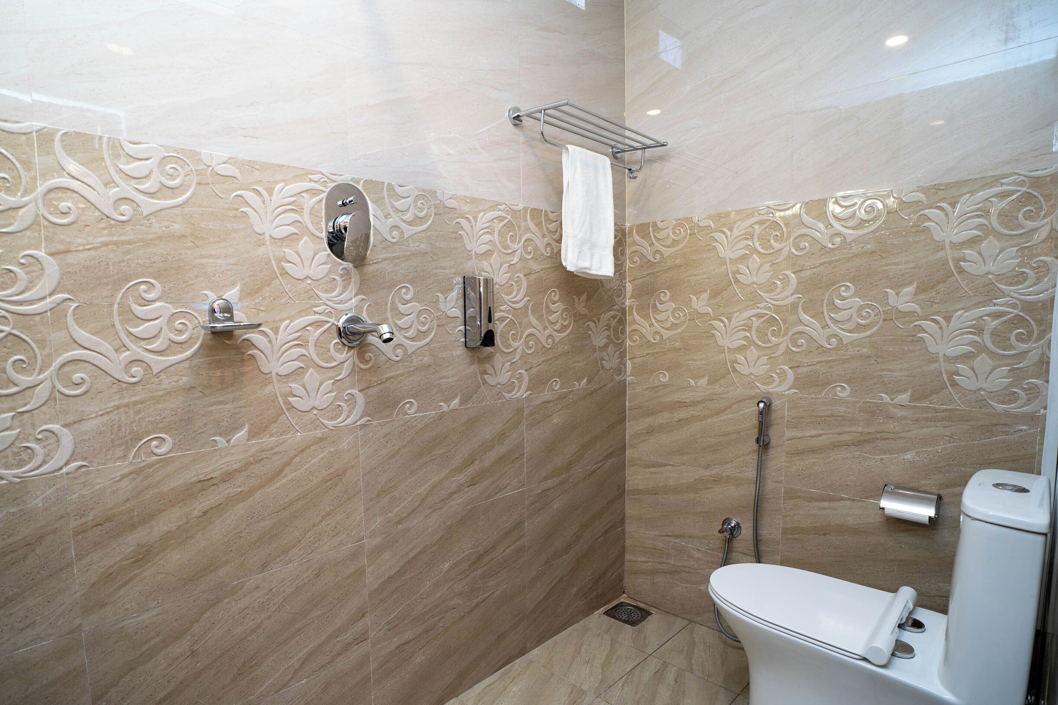 A modern bathroom with a shower, toilet, and decorative wall tiles.