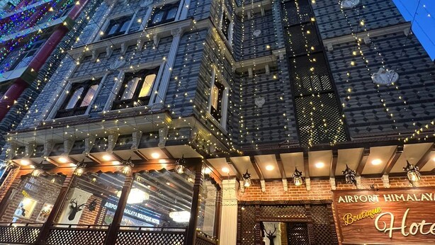 A hotel with a brick facade, a sign for 'Airport Himalaya Boutique Hotel', and a car parked in front. - Airport Himalaya Boutique Hotel (Kathmandu)